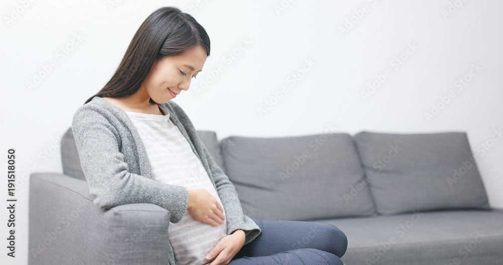 Pregnant woman looking at her tummy at home Pregnant woman looking at her tummy at home
