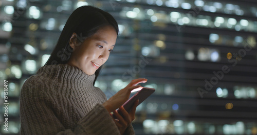 Photography Woman sending sms on cellphone at night