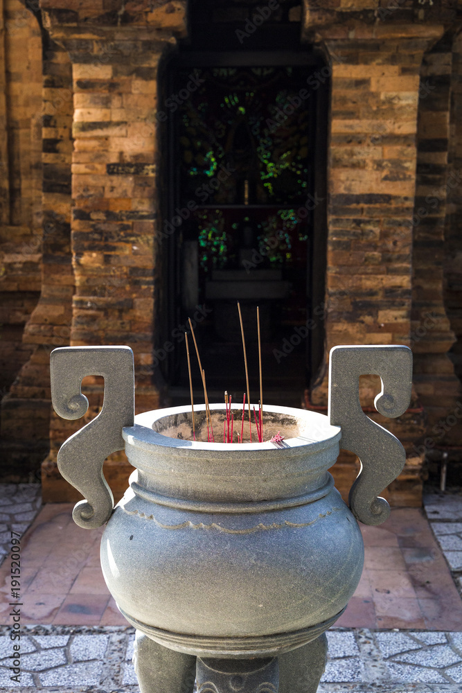 burning incense sticks in a special decorated bowl with temple on a background burning incense sticks in a special decorated bowl with temple on a background