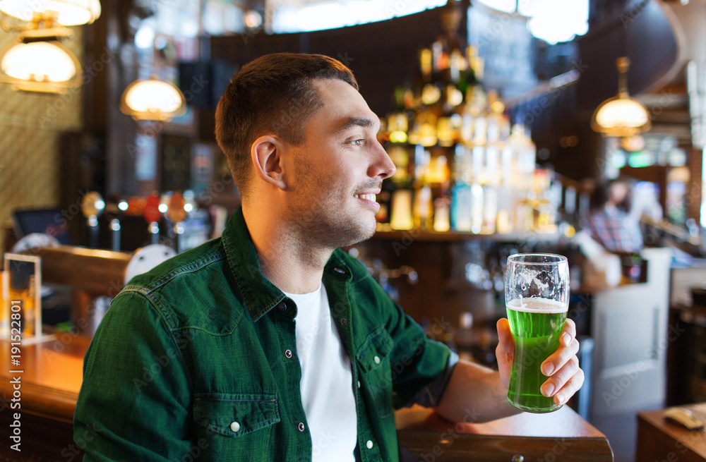 man drinking green beer at bar or pub man drinking green beer at bar or pub