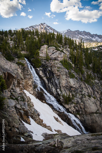 A large waterfall in the mountains of Colorado during summer. 
