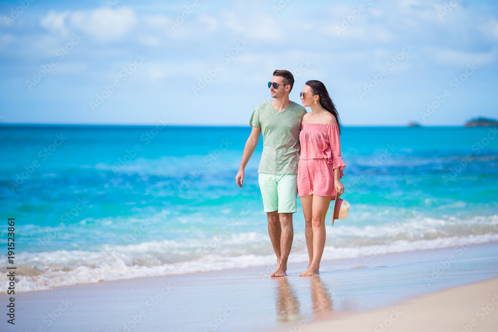 Young couple on white beach. Happy family on honeymoon vacation