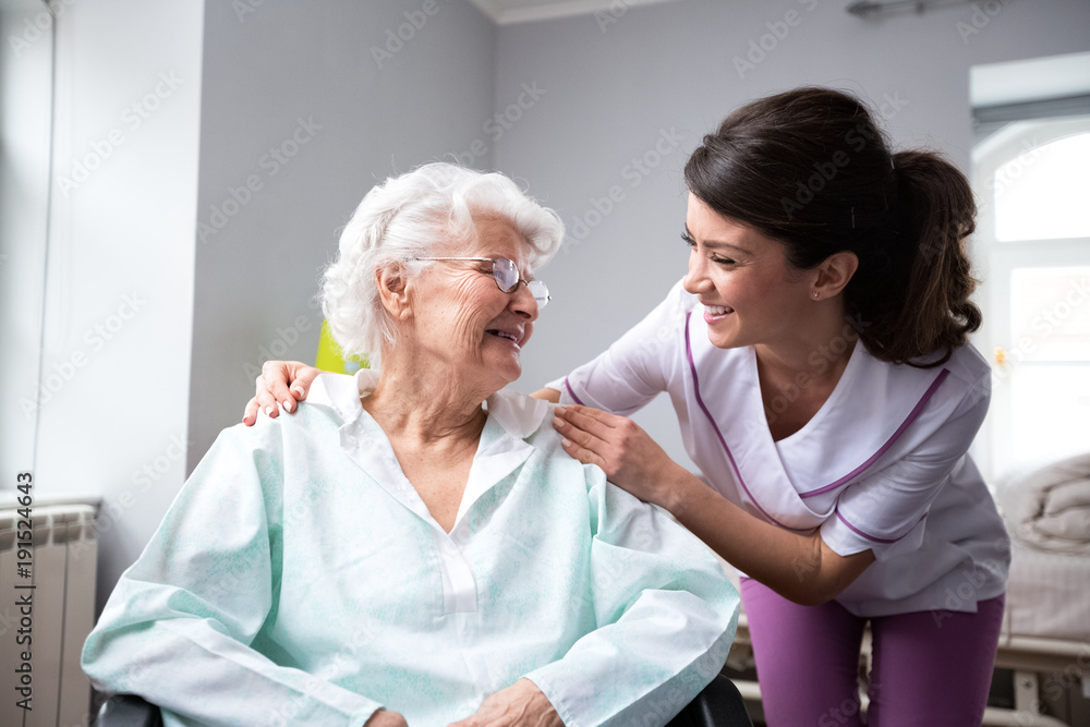 Satisfied and happy senior woman patient with nurse - obrazy, fototapety, plakaty 