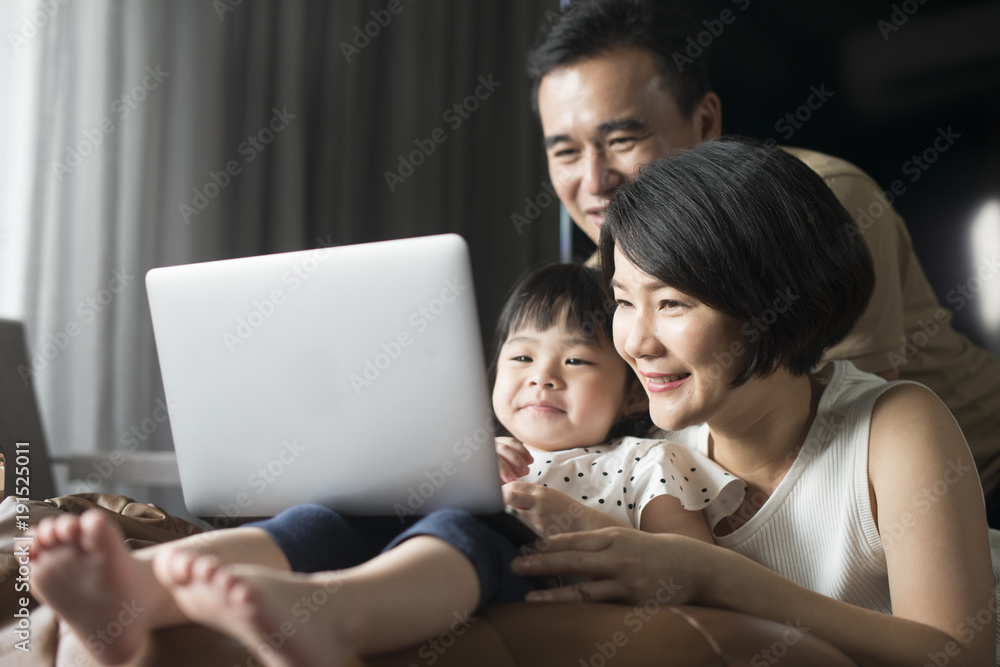 Happy Asian family looking at the computer together at home. Happy Asian family looking at the computer together at home.