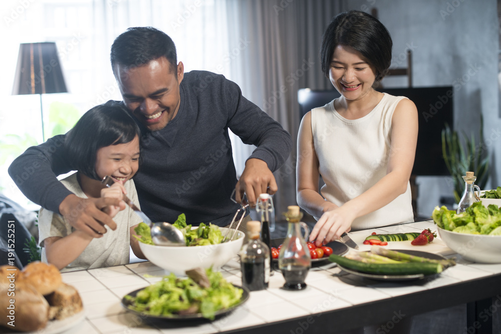 Fotografie Happy Asian family preparing food in the kitchen.