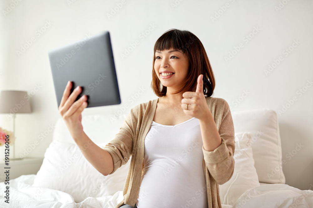 happy pregnant asian woman with tablet pc at home happy pregnant asian woman with tablet pc at home