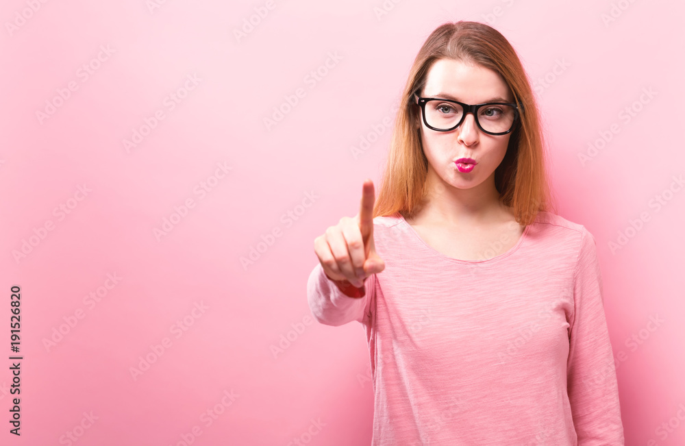 Young woman pointing at something on a solid background Young woman pointing at something on a solid background