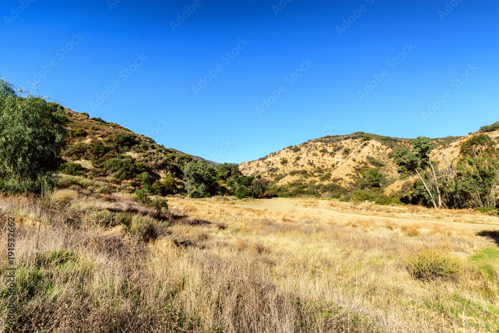 Hiking into dry California hillside on sunny morning Hiking into dry California hillside on sunny morning
