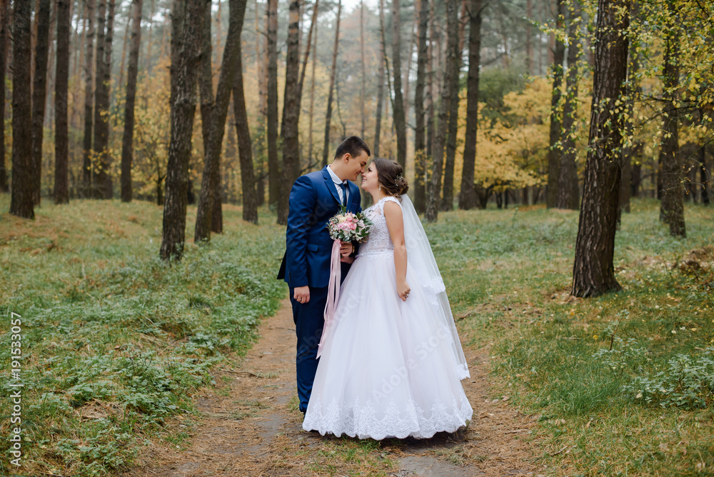 happy bride and groom walking in the autumn forest happy bride and groom walking in the autumn forest
