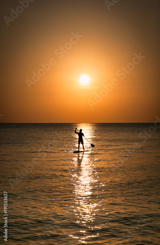 Silhouette of man standing up at paddle Board on sunset, Boracay. Philippines.