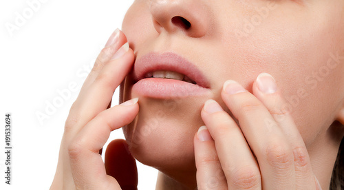 Healthy lips closeup without makeup. Hands show beautiful mouth without lipstick. Nails without nail-varnish polish. Beauty. Face without cosmetics on white background.