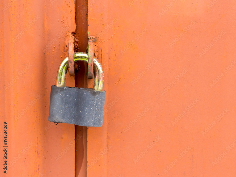 Lock hanging on old red rusty garage door with copy space Lock hanging on old red rusty garage door with copy space