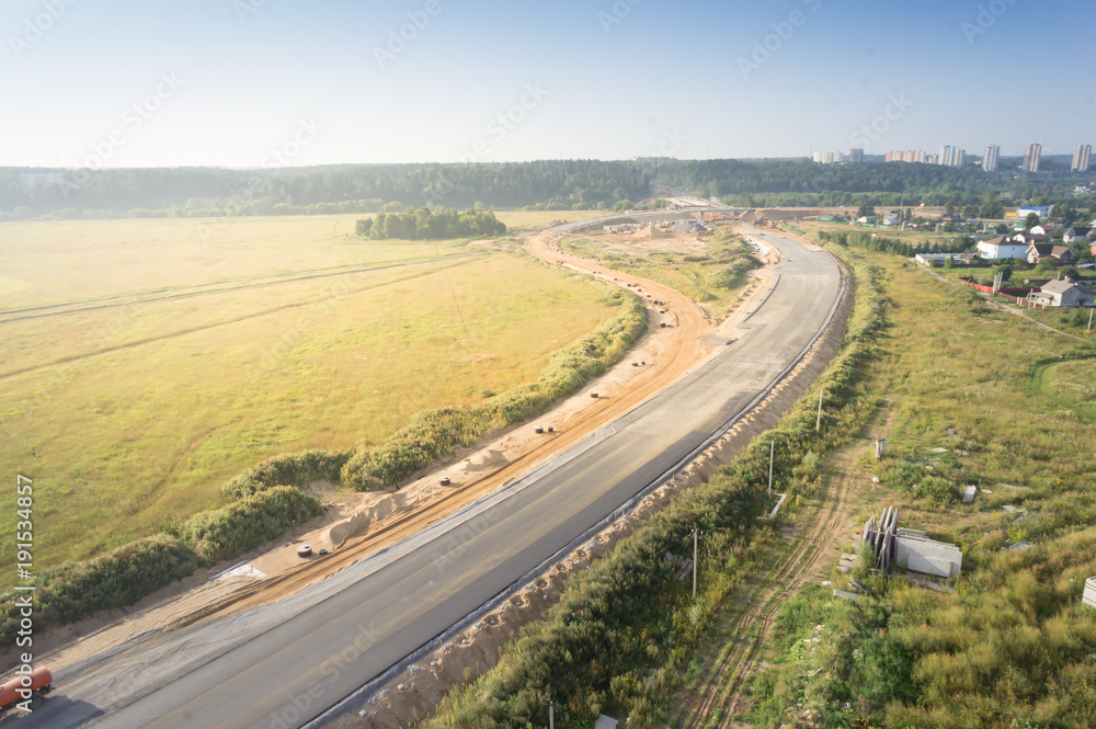 Brand new freeway. Motorway between green fields in summer day