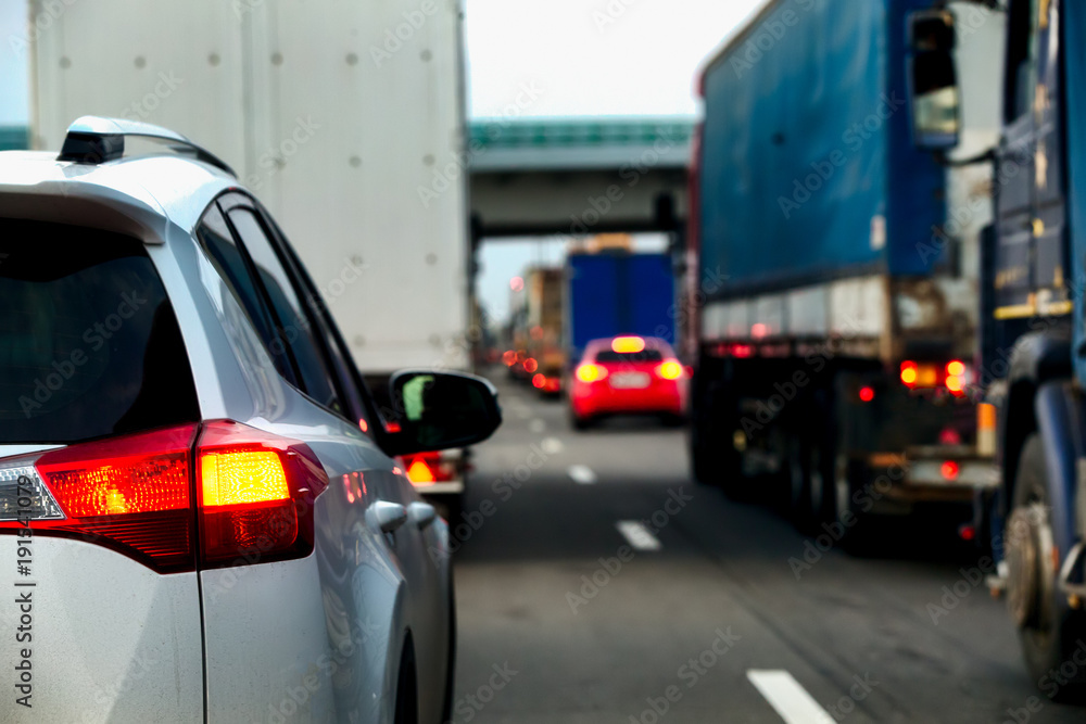 Intense traffic flow of trucks and cars. Jam on the highway. Road repair works. Rear view. Intense traffic flow of trucks and cars. Jam on the highway. Road repair works. Rear view.