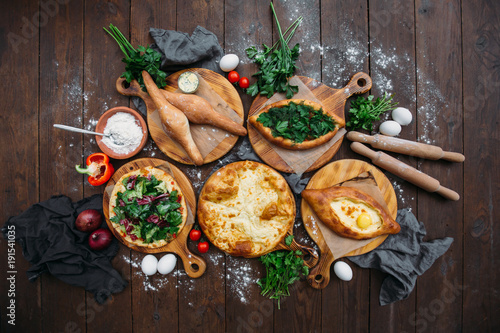 Traditional Georgian adjara khachapuri and Kolkh khachapuri on the table. Homemade baking. Top view. Flat lay
