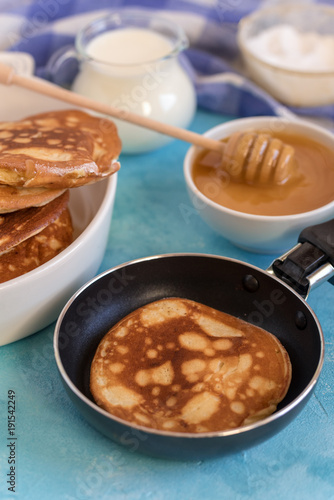Fluffy and delicate pancakes with honey and milk.