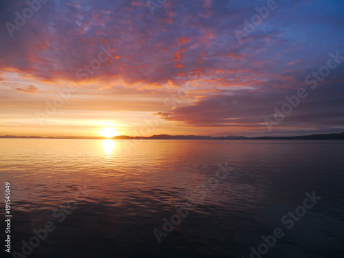 Beautiful pink and orange sunset in Alaska waters - amazing contrast with sunset and clounds © Paulo