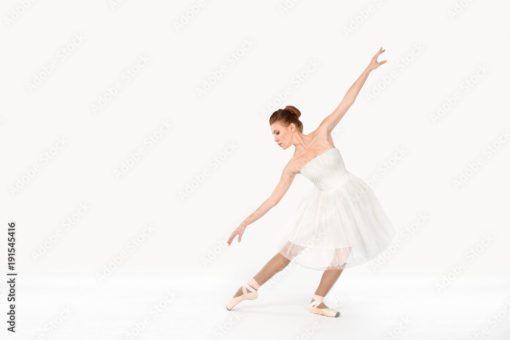 the ballerina in pointes and a dress dances on a white background