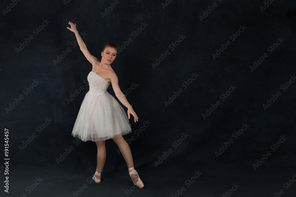 the ballerina in pointes and a dress dances on a dark background