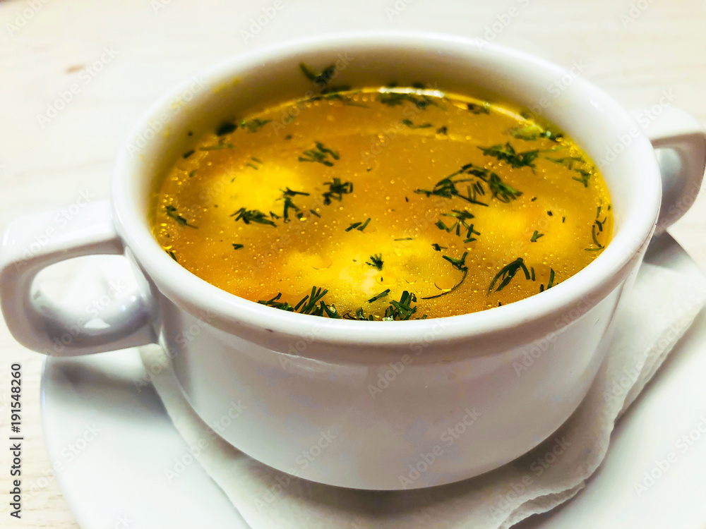 Chicken hot broth in white soup tureen Chicken hot broth in white soup tureen