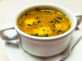 Chicken hot broth in white soup tureen