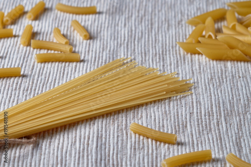 Raw spaghetti and pasta on a gray background