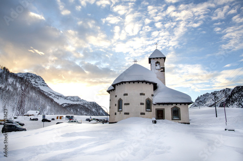 Passo San Pellegrino. Little church situated in the Dolomites, at Passo San Pellegrino. Ski resort, Ski slope. Mountains alps. Moena, Italy, Alps. Snowy winter Alps mountains at sunny day. Sunset