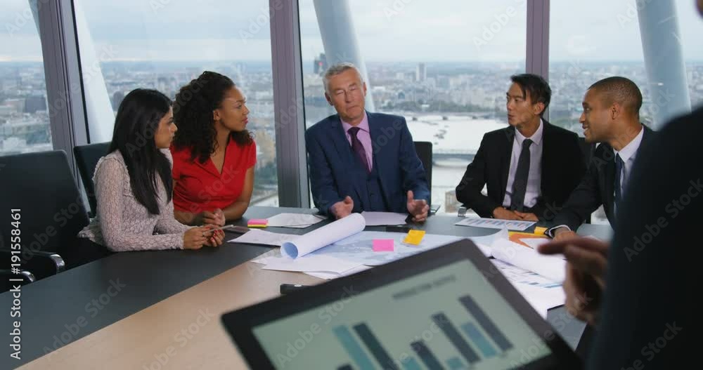 4k, An executive leading a digital presentation to colleagues in a large boardroom. 4k, An executive leading a digital presentation to colleagues in a large boardroom.