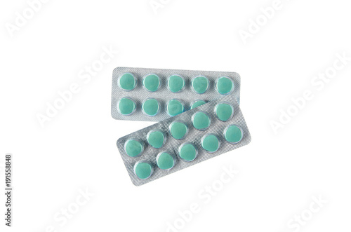two plates of green pills on white isolated background photo