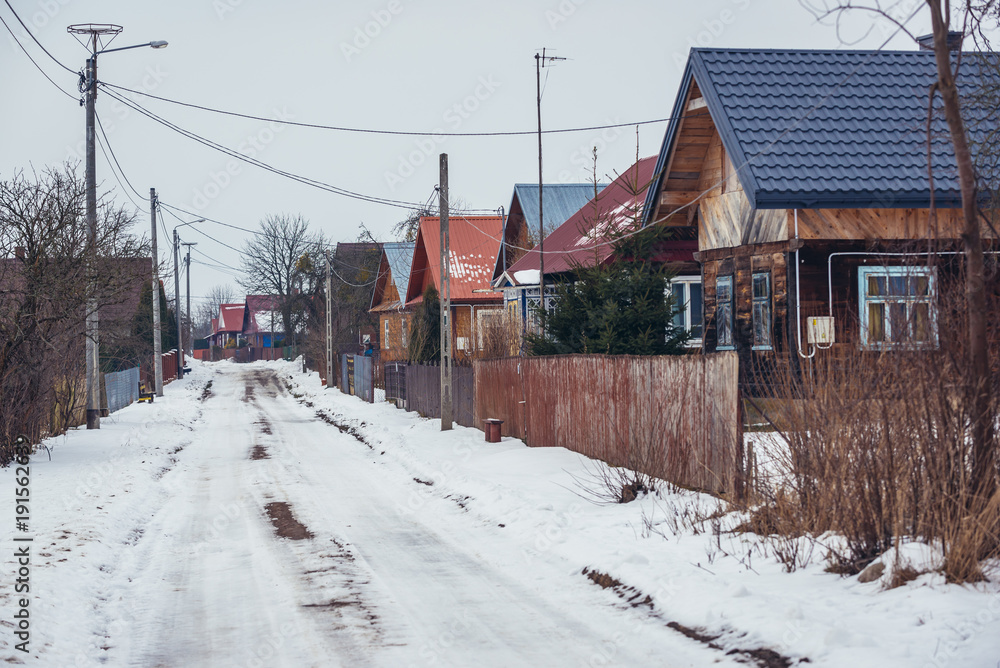 Road with traditional wooden folk cottages in Soce, small village in Podlasie region of Poland