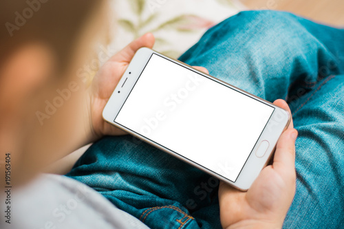 Kid using boy smartphone during a sunny day White screen for mock up photo