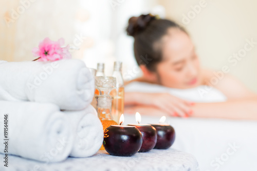 Spa massage setting product with rolled, towel, compress balls ,Ingredients for cosmetics, body massage and thai spa.Blurred background is asian woman in spa shop.