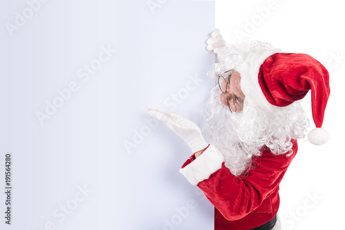 Santa Claus pointing in white blank sign with smile, isolated on white background. .copy space for Advertising christmas and happy new year festival