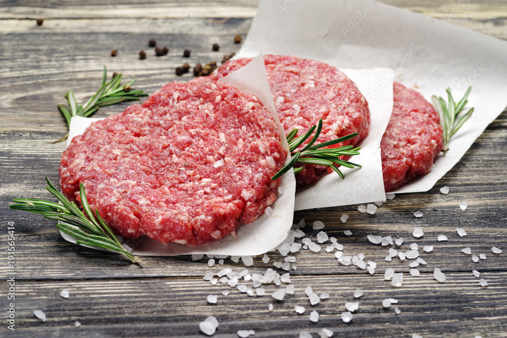 Fresh raw chopped meat for burgers on a wooden table. Fresh raw chopped meat for burgers on a wooden table.