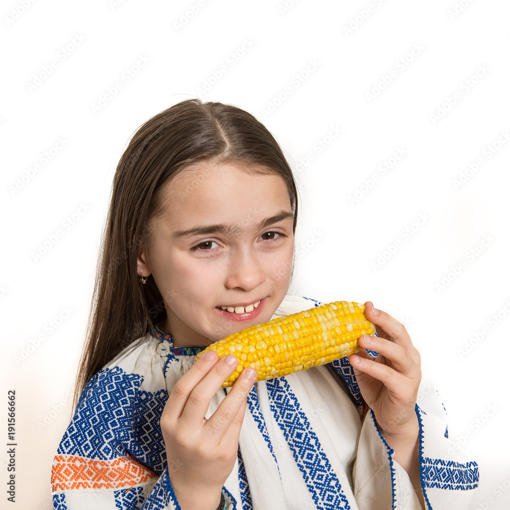 Indoor close up portrait of a smiling young girl getting ready to eat a corn cob. Indoor close up portrait of a smiling young girl getting ready to eat a corn cob.