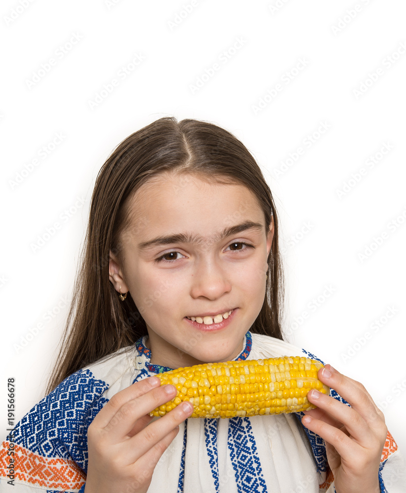 Indoor close up portrait of a smiling young girl getting ready to eat a corn cob. Indoor close up portrait of a smiling young girl getting ready to eat a corn cob.