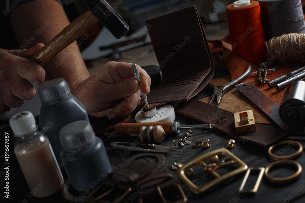 Man working with leather using crafting DIY tools Man working with leather using crafting DIY tools