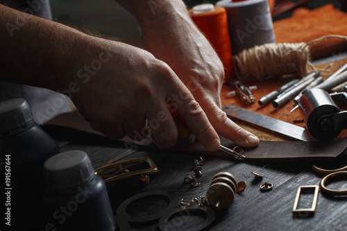 Man working with leather using crafting DIY tools