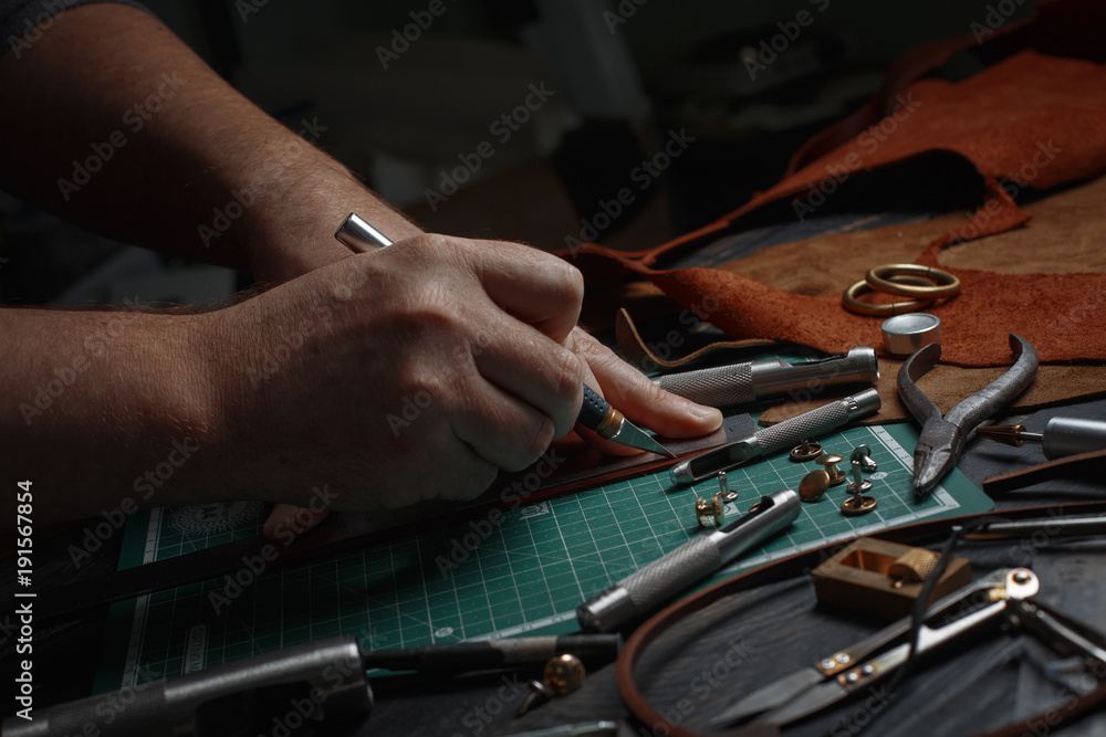 Man working with leather using crafting DIY tools Man working with leather using crafting DIY tools