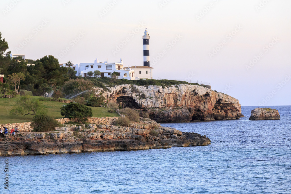 Europe, Spain, Balearic Islands, Mallorca. Porto Colom. Walkway along the waterfront. lighthouse.