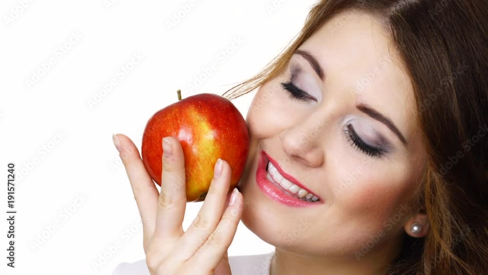 Woman toothy smile brunette female holding red apple fruit in hand close to face, isolated on white. Healthy eating, vegetarian food, diet concept. Woman toothy smile brunette female holding red apple fruit in hand close to face, isolated on white. Healthy eating, vegetarian food, diet concept.