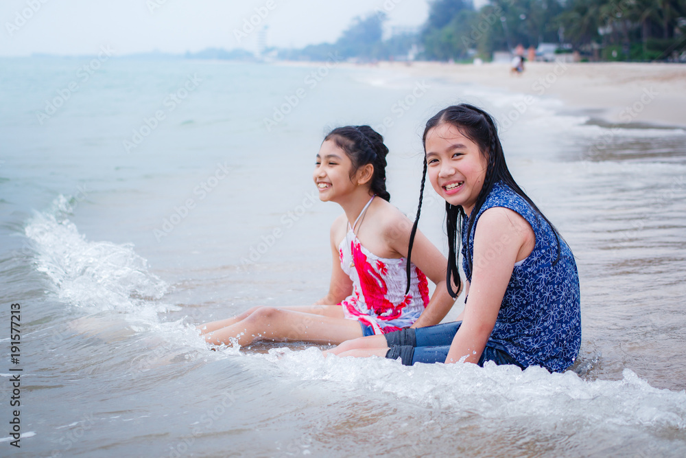 Obraz premium Two little girls are on the beach.