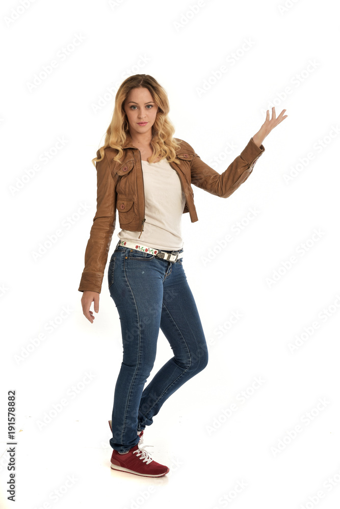 full length portrait of blonde girl wearing simple brown jacket and jeans, standing pose on white studio background. full length portrait of blonde girl wearing simple brown jacket and jeans, standing pose on white studio background.