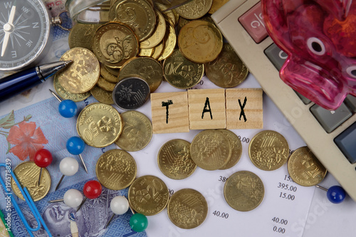 TAX CONCEPT. Coins,calculator,bank notes and wood plate on a white table. photo