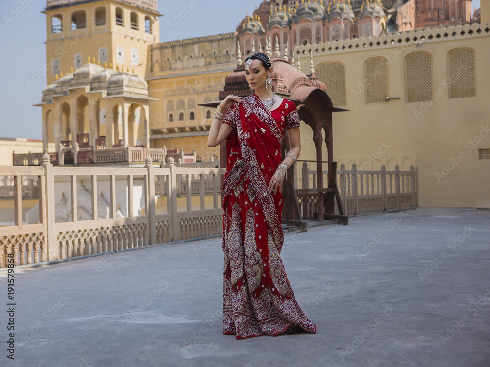 Maharani in Hawa Mahal. Young indian woman in traditional clothing with bridal makeup and oriental jewelry.