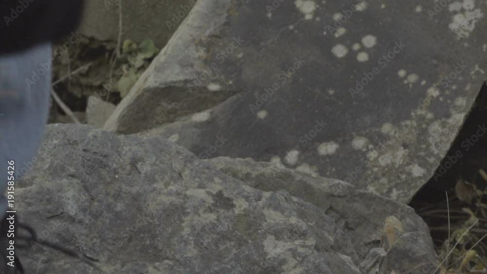 Hiker climbing rocks reaching top, low angle shot feet boots slow motion Hiker climbing rocks reaching top, low angle shot feet boots slow motion