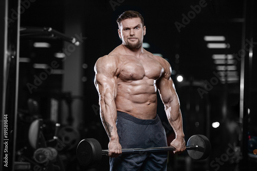 Brutal strong bodybuilder athletic men pumping up muscles with dumbbells.