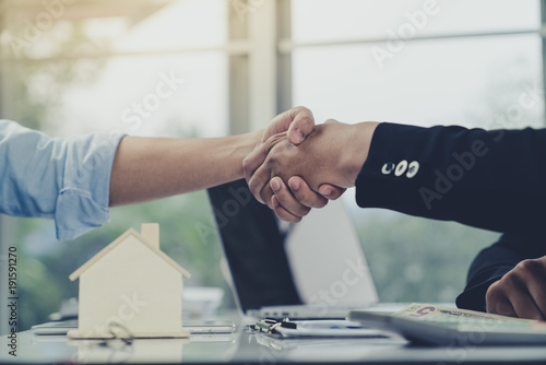 Young businessman and home buyer customer had achieve target means together and signed in the contract of sale of real estate and paying down payment to realtor