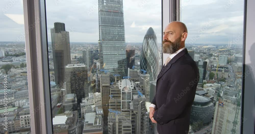 4k, Portrait of a confident businessman standing in an office with London skyline in the background. Slow motion. 4k, Portrait of a confident businessman standing in an office with London skyline in the background. Slow motion.