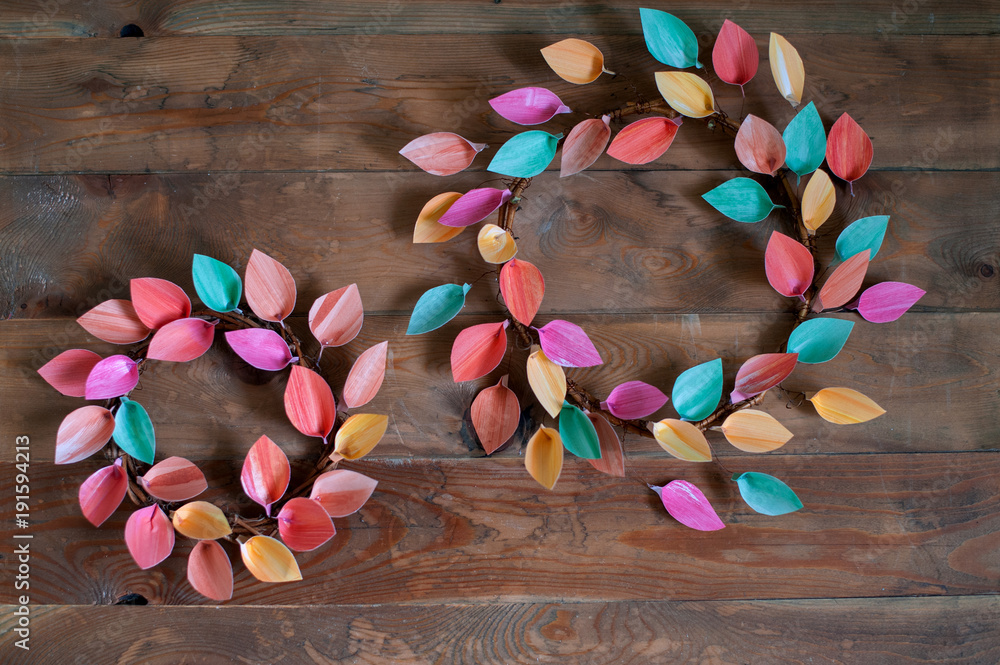 Two paper wreaths on grunge wooden background
